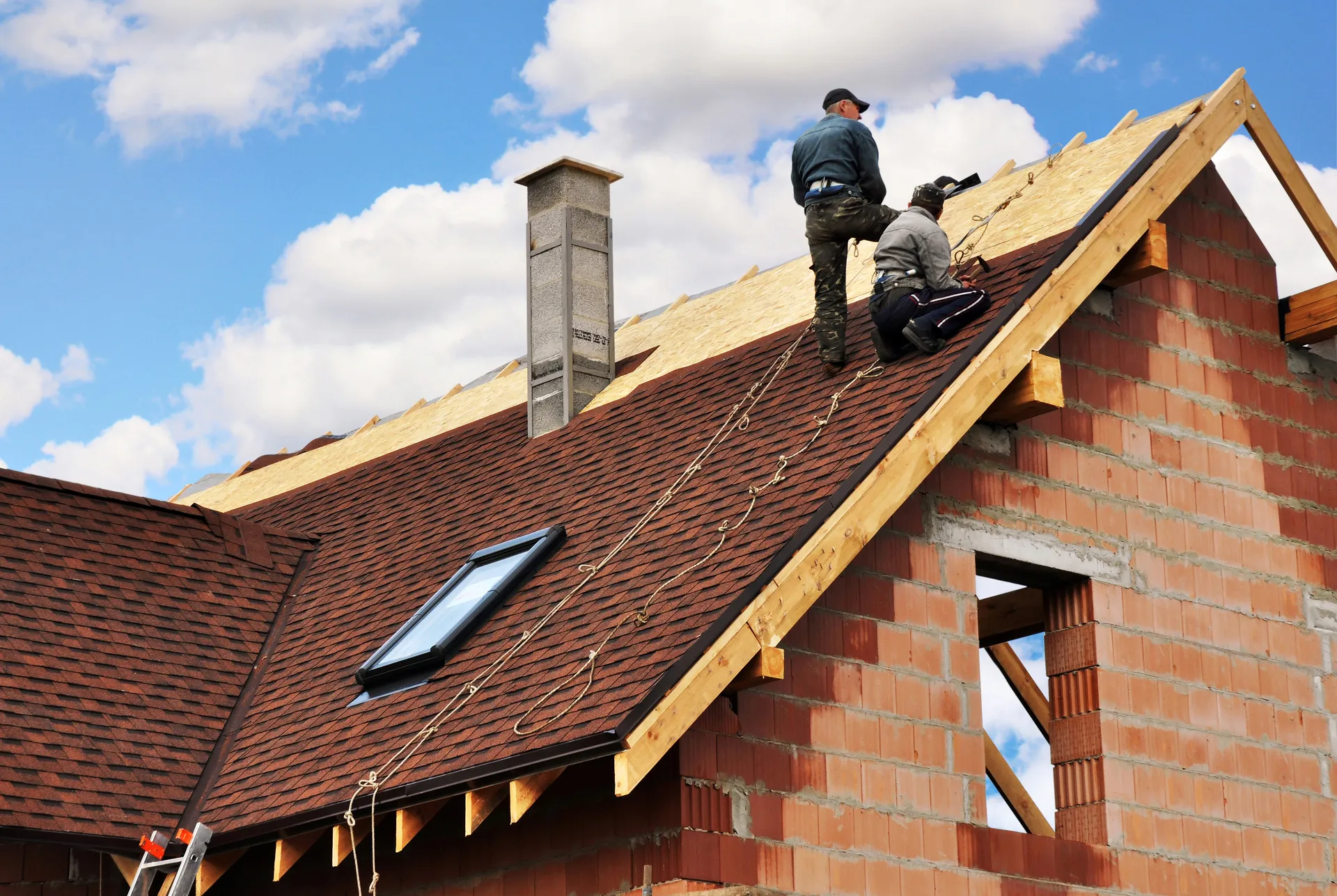 Roofers working on a tiled house roof